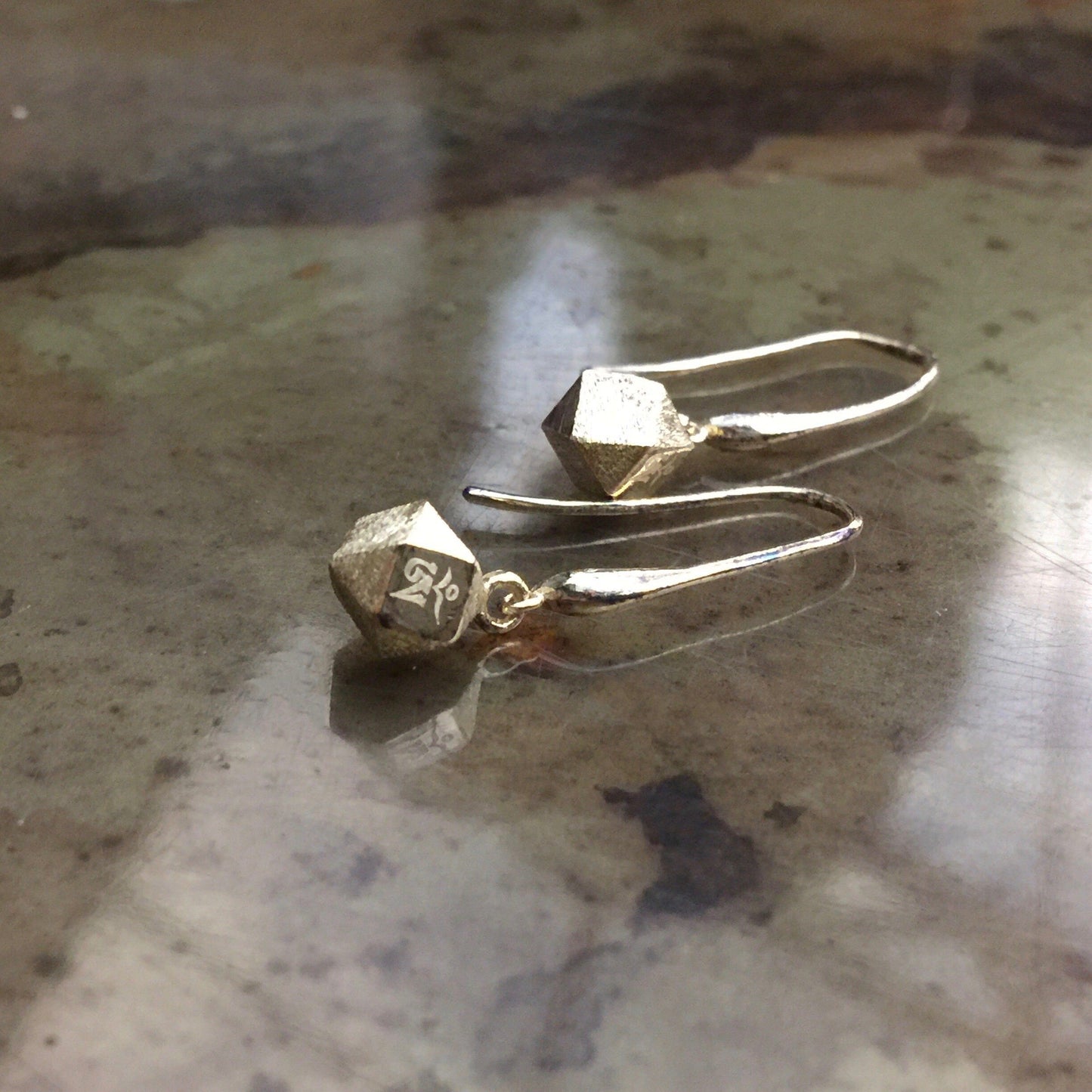Mantra Cube Earrings - Engraved on a marble table