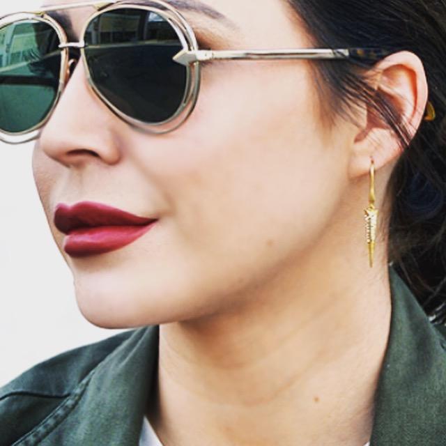 Blogger Taylor Stone wearing camouflage jacket white t shirt and Mantra Dagger Drop Earrings