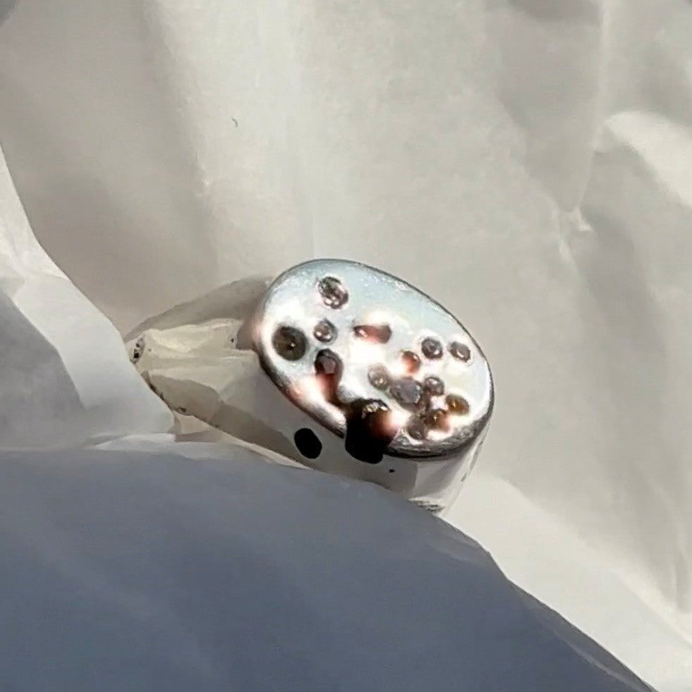 Joni sand cast ring on side with sapphires in tissue paper