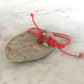 Red strings of destiny bracelets With Red Carnelian Bracelet on rock