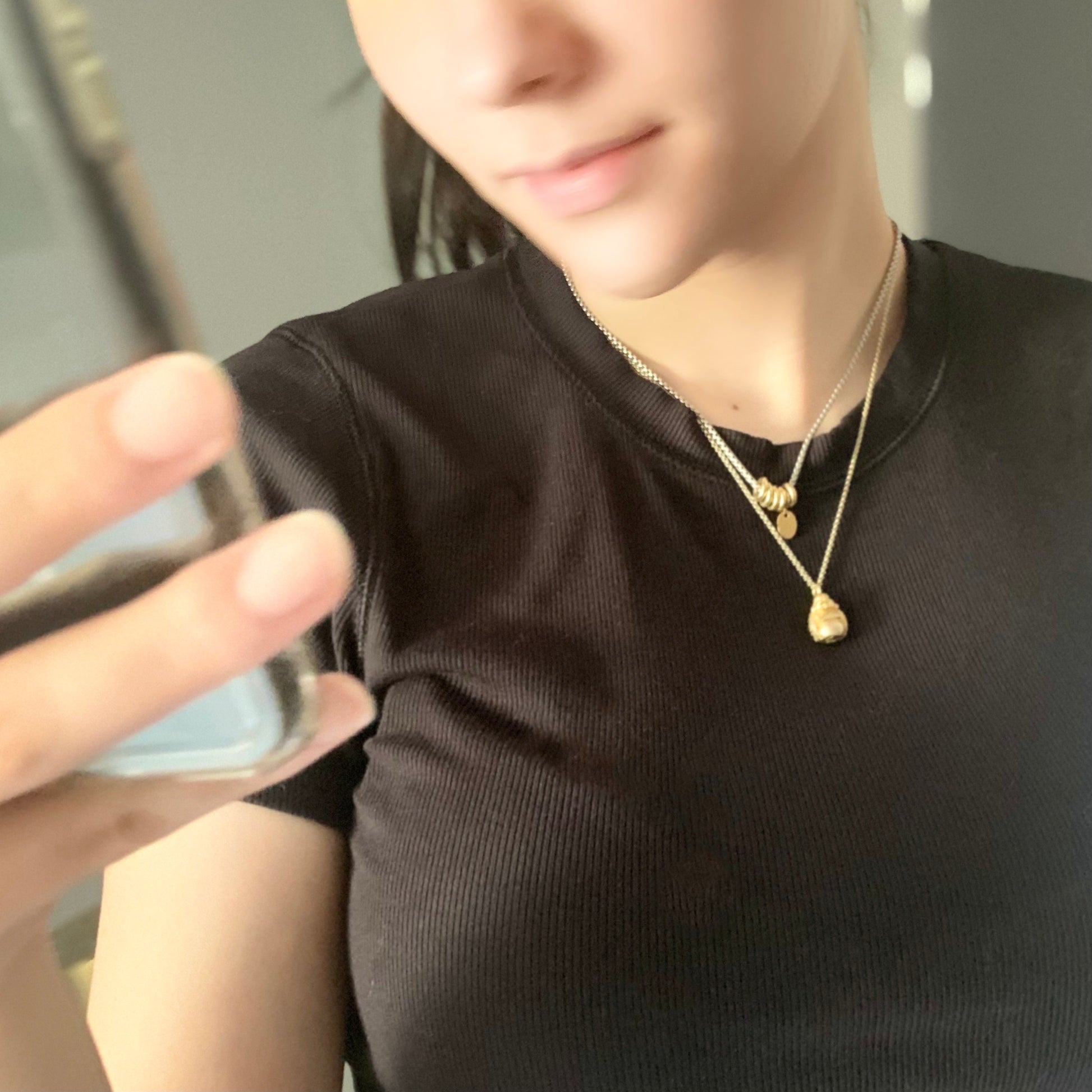 Girl wearing Khai Necklace - Steel box chain with 925 Silver Rings Vermeil plated in 18K gold and Laughing Buddha necklace in Silver and gold plated