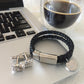 Bracelet - Unisex Leather Braided Bracelet With Steel Clasp And Dragon Cufflinks sitting on a computer with coffee in the background