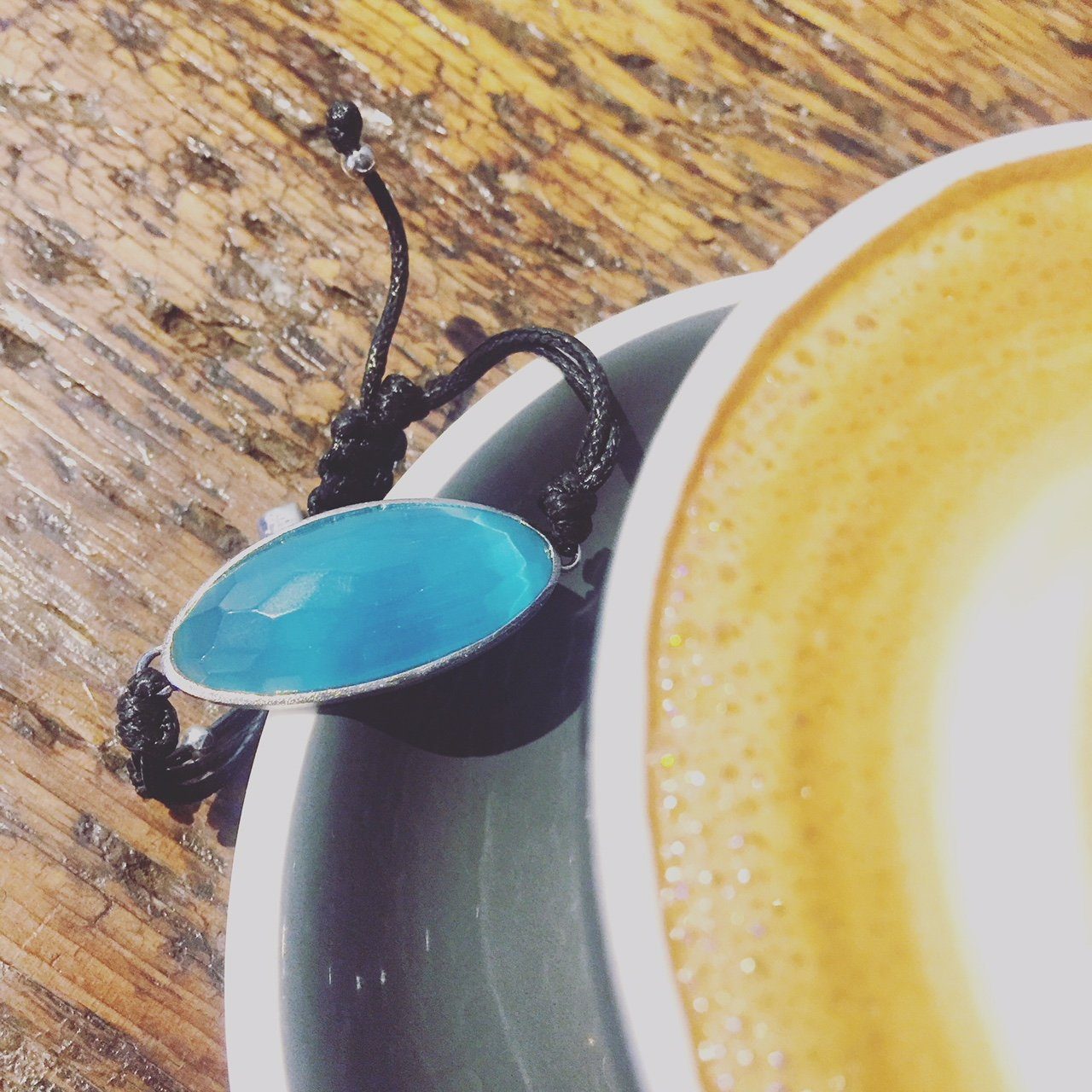 Blue Inclusiveness Bracelet - Dress For Success Vancouver | Values Bracelet on the edge of a coffee cup