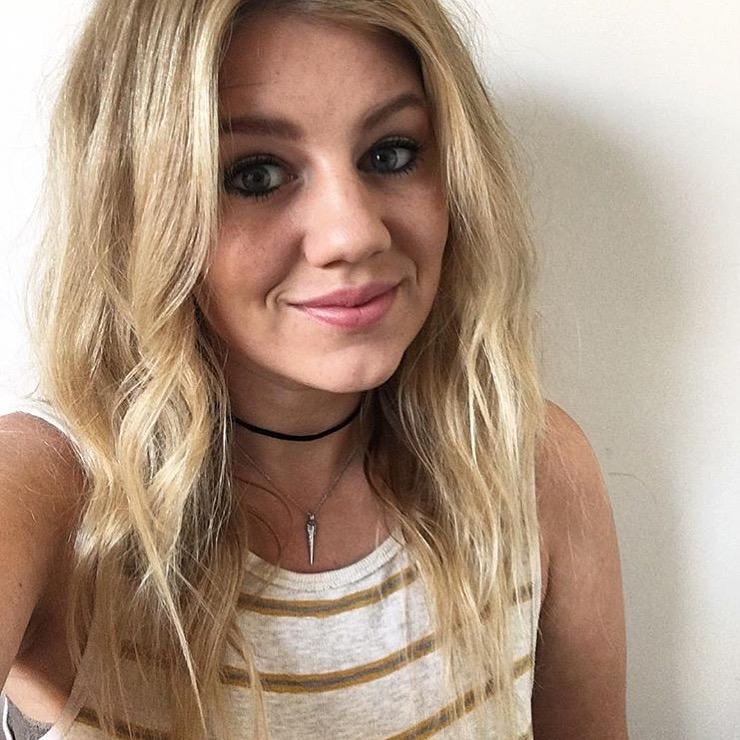 Blond boho chic girl in a striped tank wearing Mantra Dagger Pavee Pendant With Swarovski Crystals