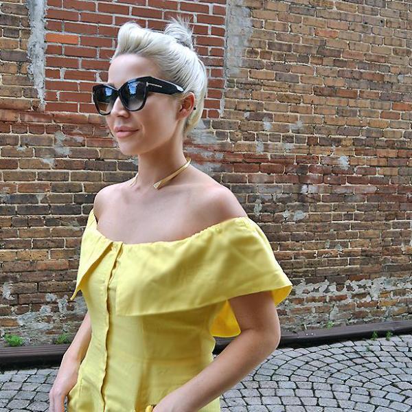 Taylor Stone of Stone Files wearing bright yellow off shoulder dress with Mantra Small Dagger Collar