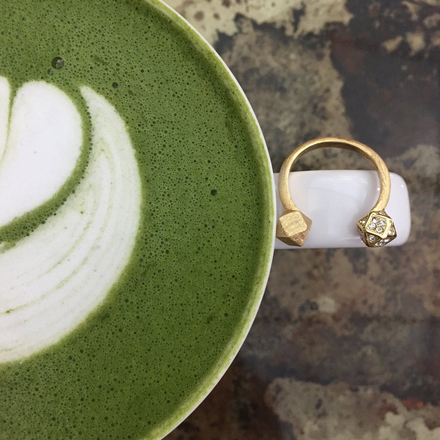 Mantra Open Cube Ring With Swarovski Crystals sitting on a white mug 